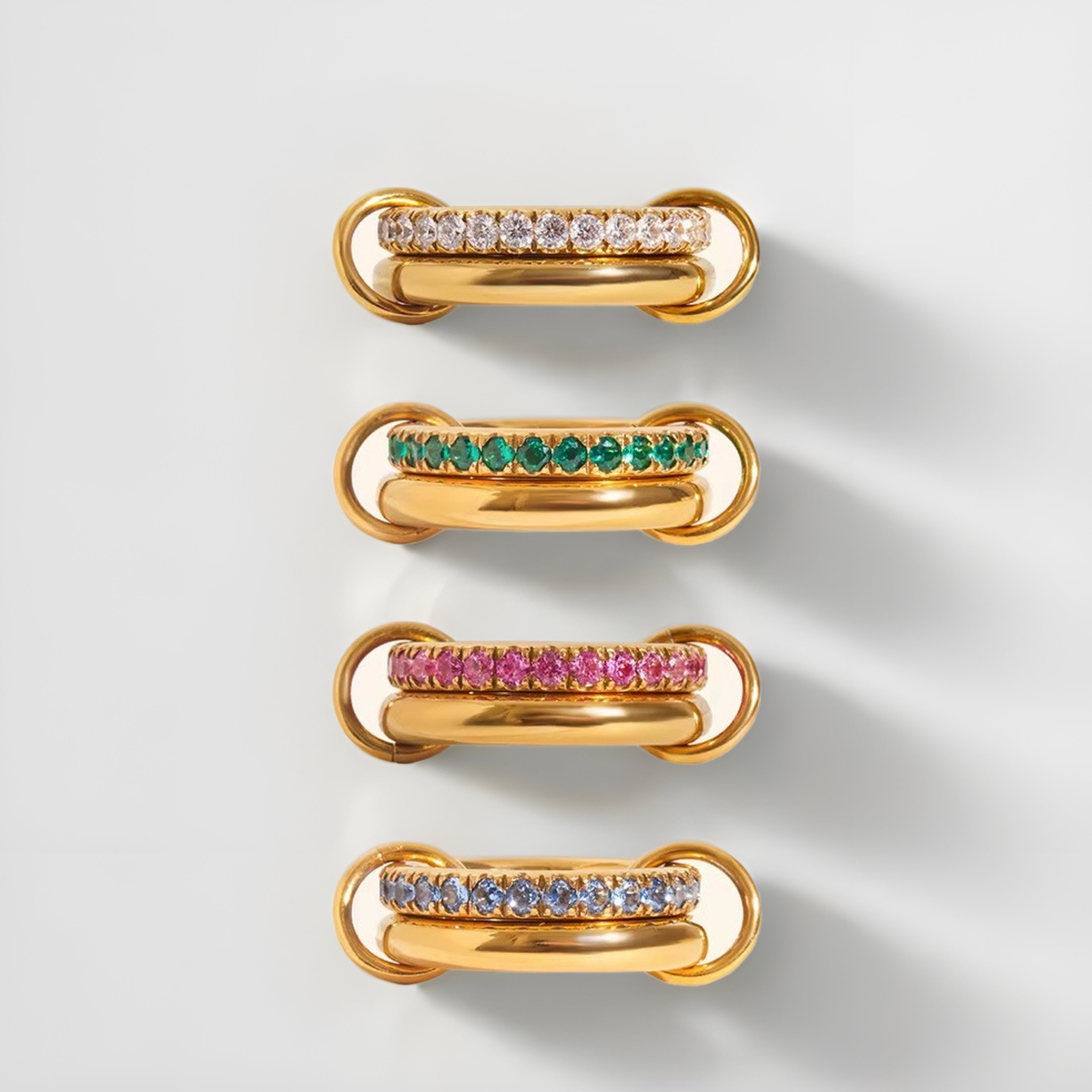 Set of gold jewelry pieces with gemstones on a light gray background